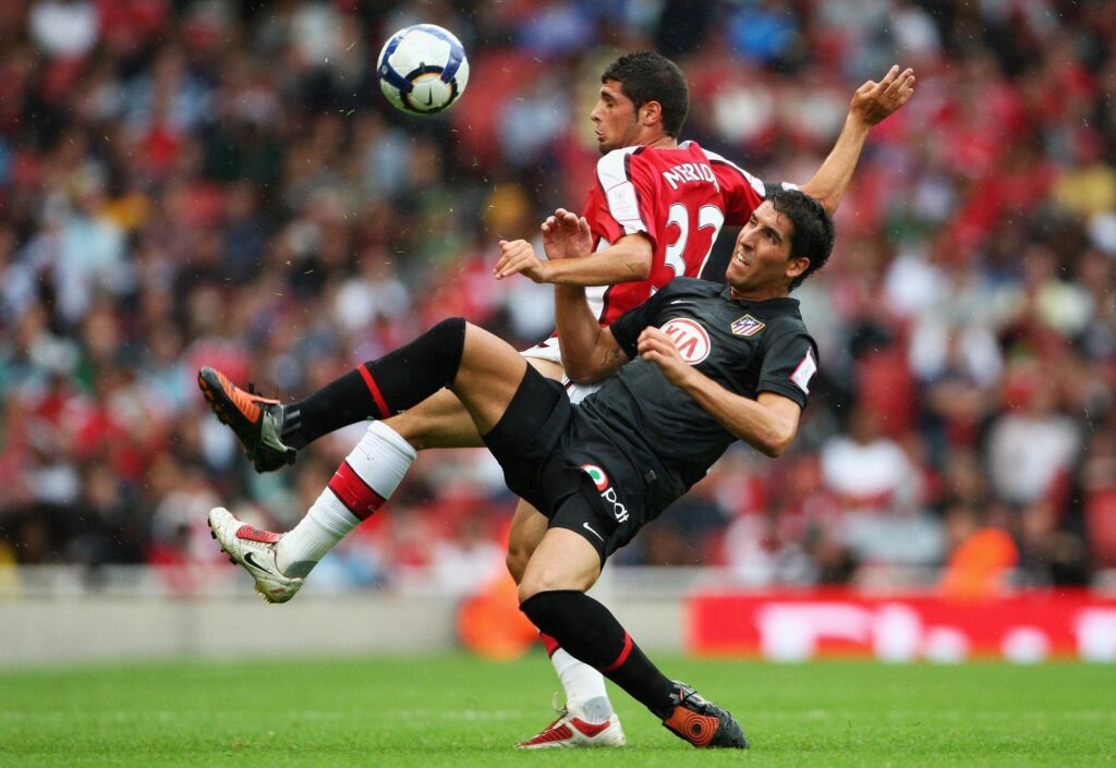 Arsenal and Atlético Madrid players competing in a high-intensity Champions League match action scene